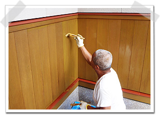 木の上塗り（仕上げ塗装）　玄関廻りの腰板を刷毛で塗装中